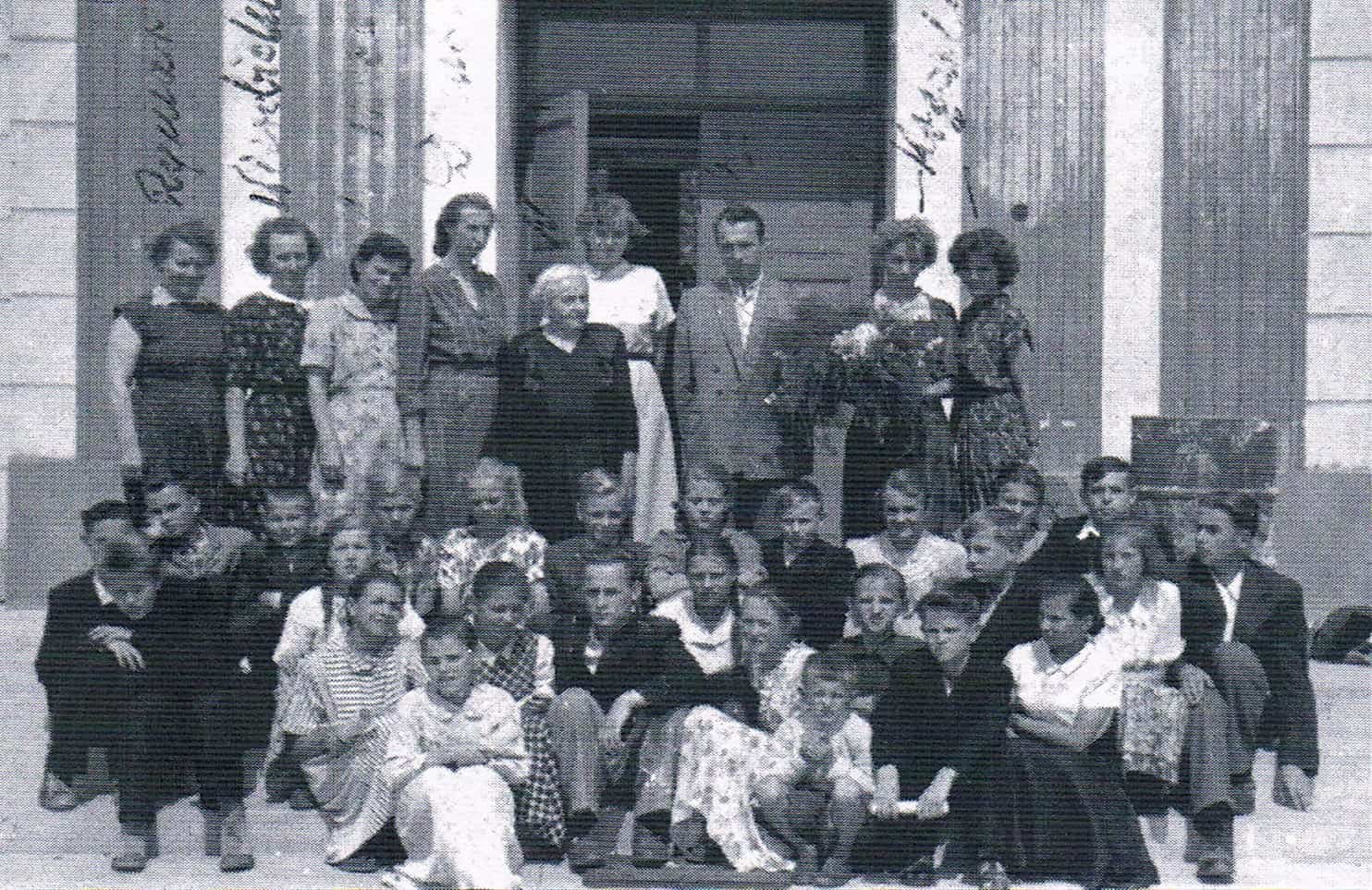 Przed wejściem do szkoły w Giedlarowej 1962 r. Nauczyciele od lewej: Rymar, Wierzbicka,Mazurek, Dziubek, Niezgoda, Klimek, Szepelak, siostry Krężałek. Ze zbiorów Edwarda Dziubka