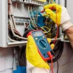 Elektryk w Giedlarowej testuje instalację elektryczną miernikiem cyfrowym w rozdzielni elektrycznej