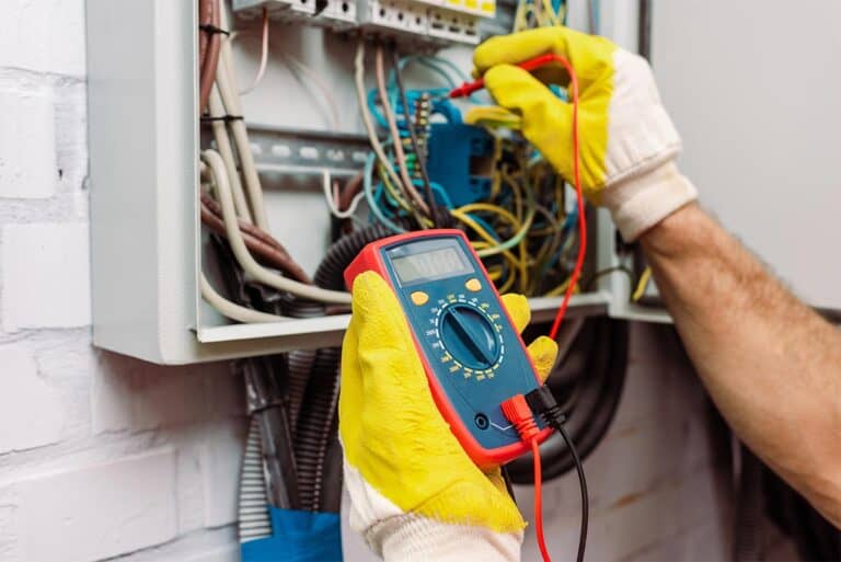 Elektryk w Giedlarowej testuje instalację elektryczną miernikiem cyfrowym w rozdzielni elektrycznej