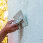 Tynkowanie ścian w Giedlarowej - wygładzanie tynku pacą, prezentując fachowe wykonanie.