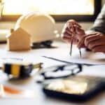 Architekt przy biurku projektuje model domu - usługi projektowe Giedlarowa.